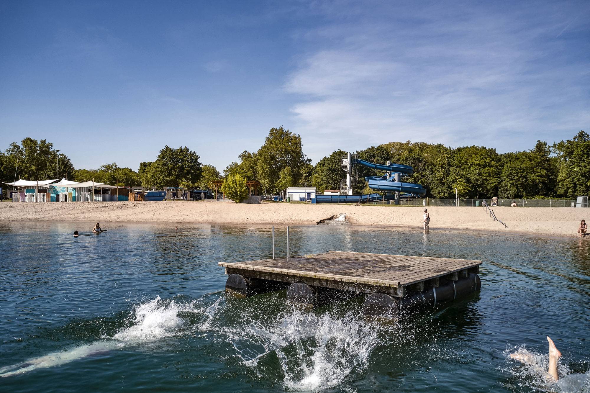 Strandbad, Holzsteg im Wasser und Rutsche im Hintergrund